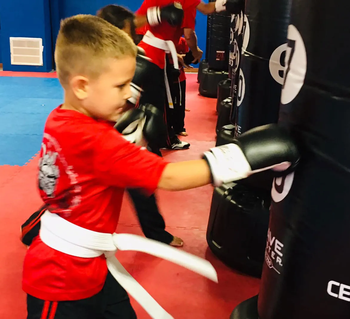martial-arts-clases-for-children-punching-bag martial arts student practicing self defense
