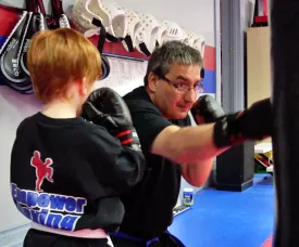 Child practicing boxing technique with instructor. Child practicing boxing technique with instructor.