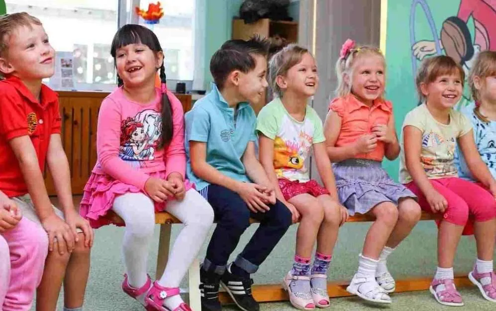 summer-camp-kids-on-bench-smiling summer camp kids on a bench and smiling